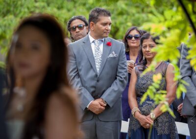 Wedding guests watching ceremony with focused expressions.