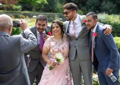 Guests smiling while posing for a photo together at outdoor wedding celebration.