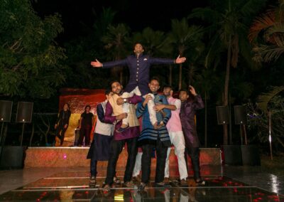 A group of men in traditional Indian attire form a human pyramid, with one man standing on top.