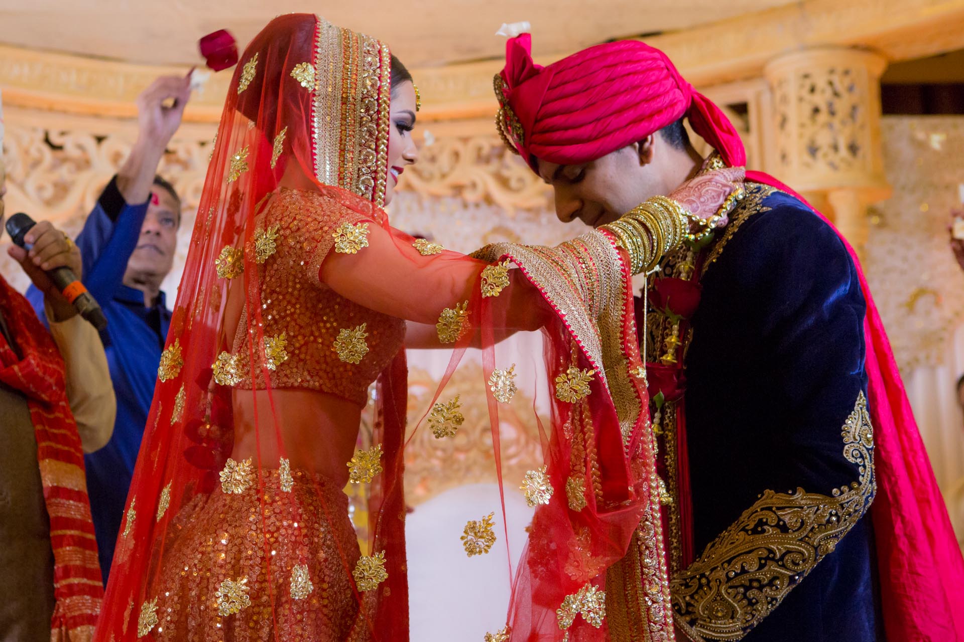 Bride placing garland on groom during traditional Hindu wedding ceremony.