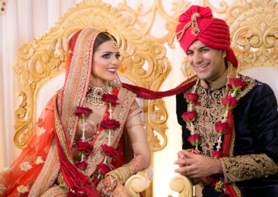 Bride and groom smiling during Hindu wedding ceremony.