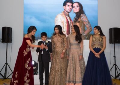 Bridesmaids and young boy giving speech on stage during wedding reception.