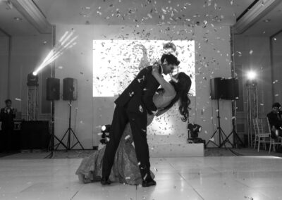 Bride and groom sharing a romantic dance under falling confetti.