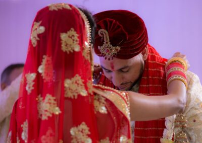 Bride placing garland around groom during Hindu wedding ritual.