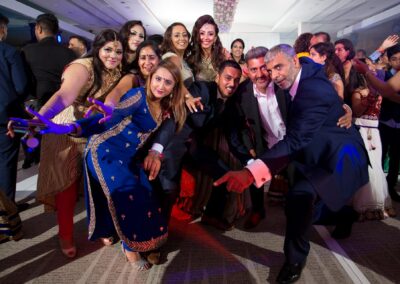 Wedding guests posing together on dance floor during celebration.