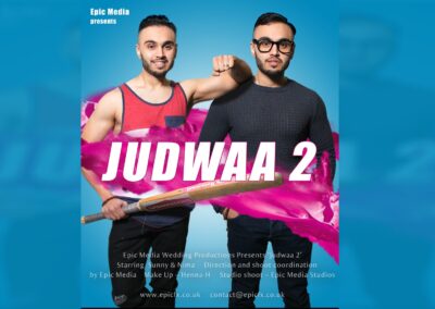 Two men posing with a cricket bat, "JUDWAA 2" in large pink letters.